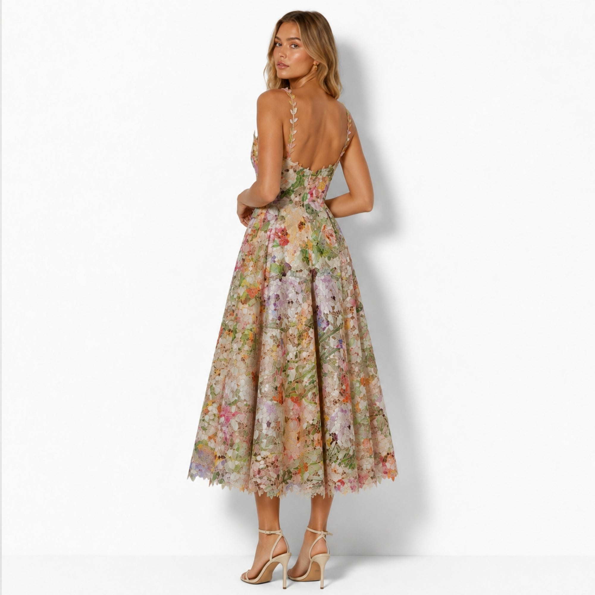 Back view of model wearing Kouvr floral lace cocktail dress showing low back, thin straps, and full skirt.