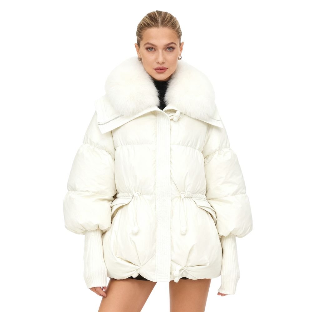 Woman wearing a white kouvr puffer coat with a fur-lined hood on a white background