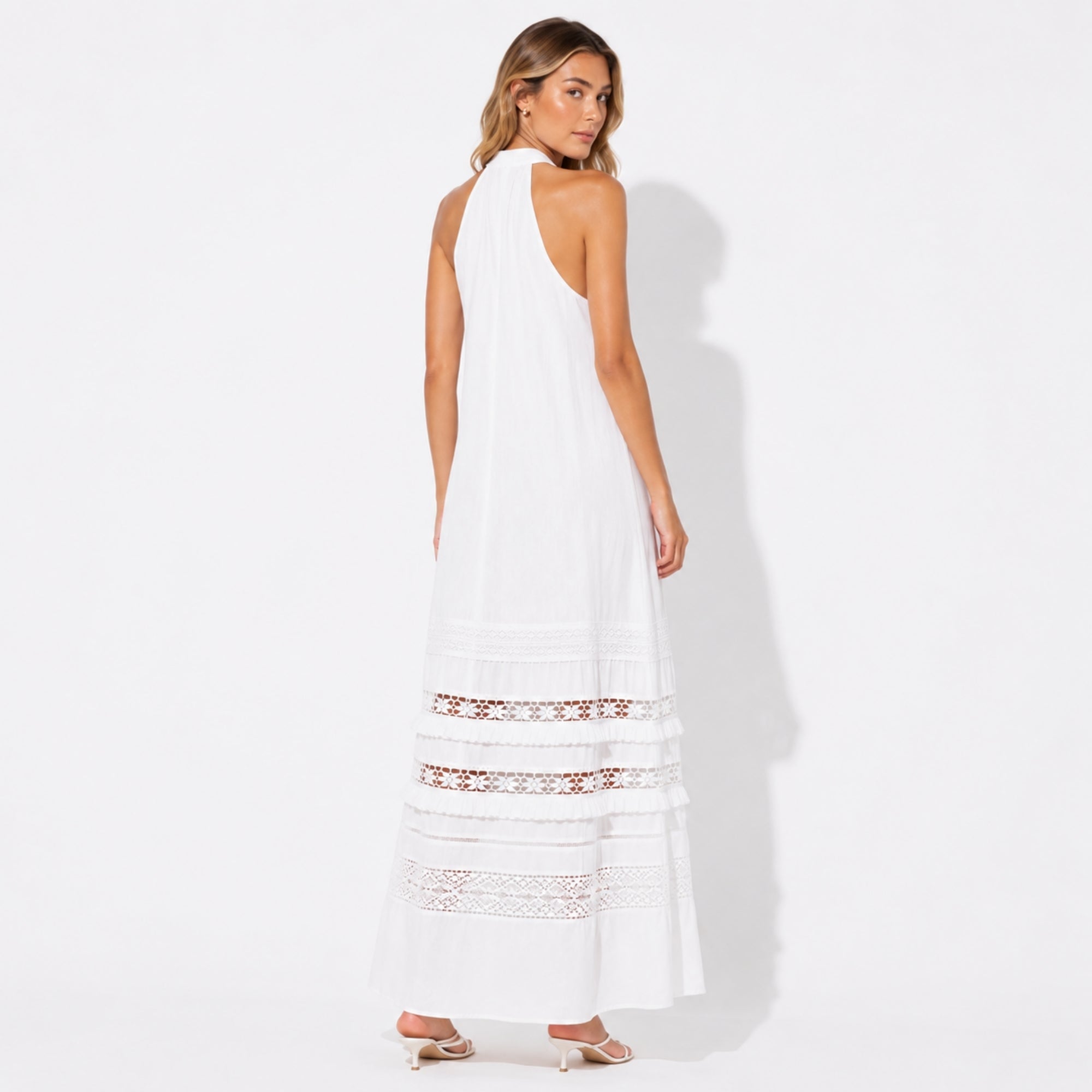 Back view of the boho luxury white halter neck vacation dress highlighting the open shoulder design.