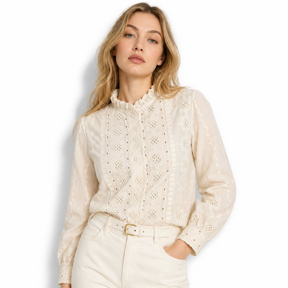 Half body shot of female model casually posing with hand in pocket wearing an affordable luxury beige cotton eyelet button-down shirt.