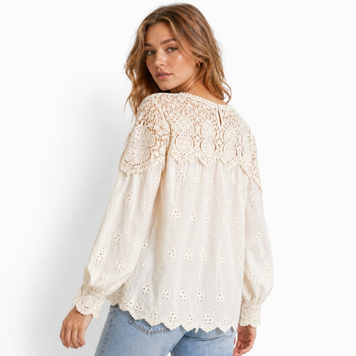 Back view of romantic beige cotton lace blouse highlighting sheer crochet shoulder panels and keyhole button closure