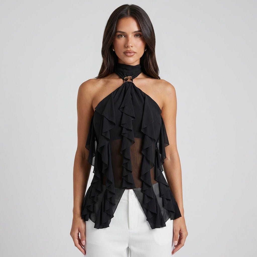 Front view of brunette model wearing Kouvr black sheer chiffon ruffle halter top with gold neck hardware styled with tailored white pants.