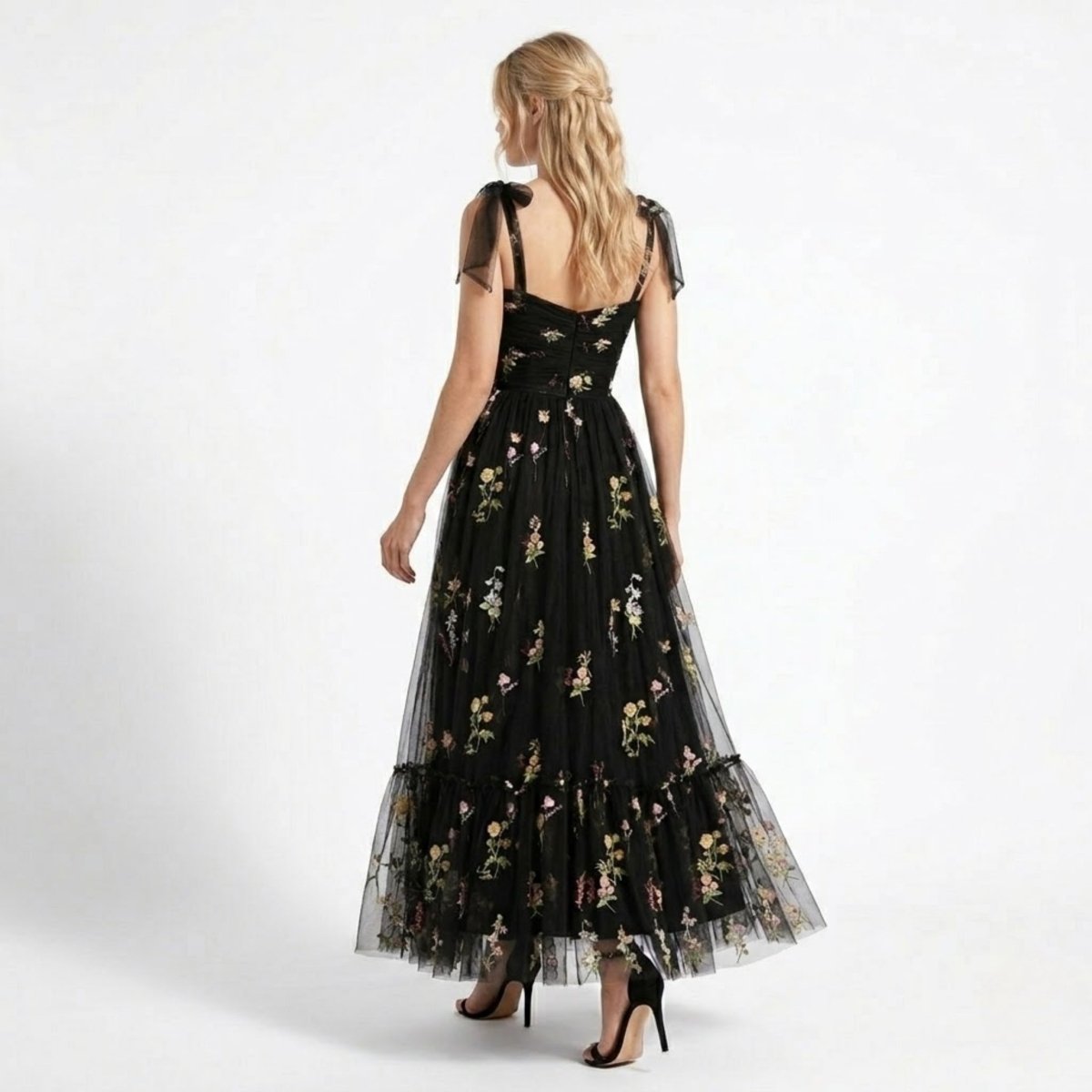 Back view of Kouvr black floral embroidered tulle maxi dress featuring concealed back zipper and sheer shoulder bows.