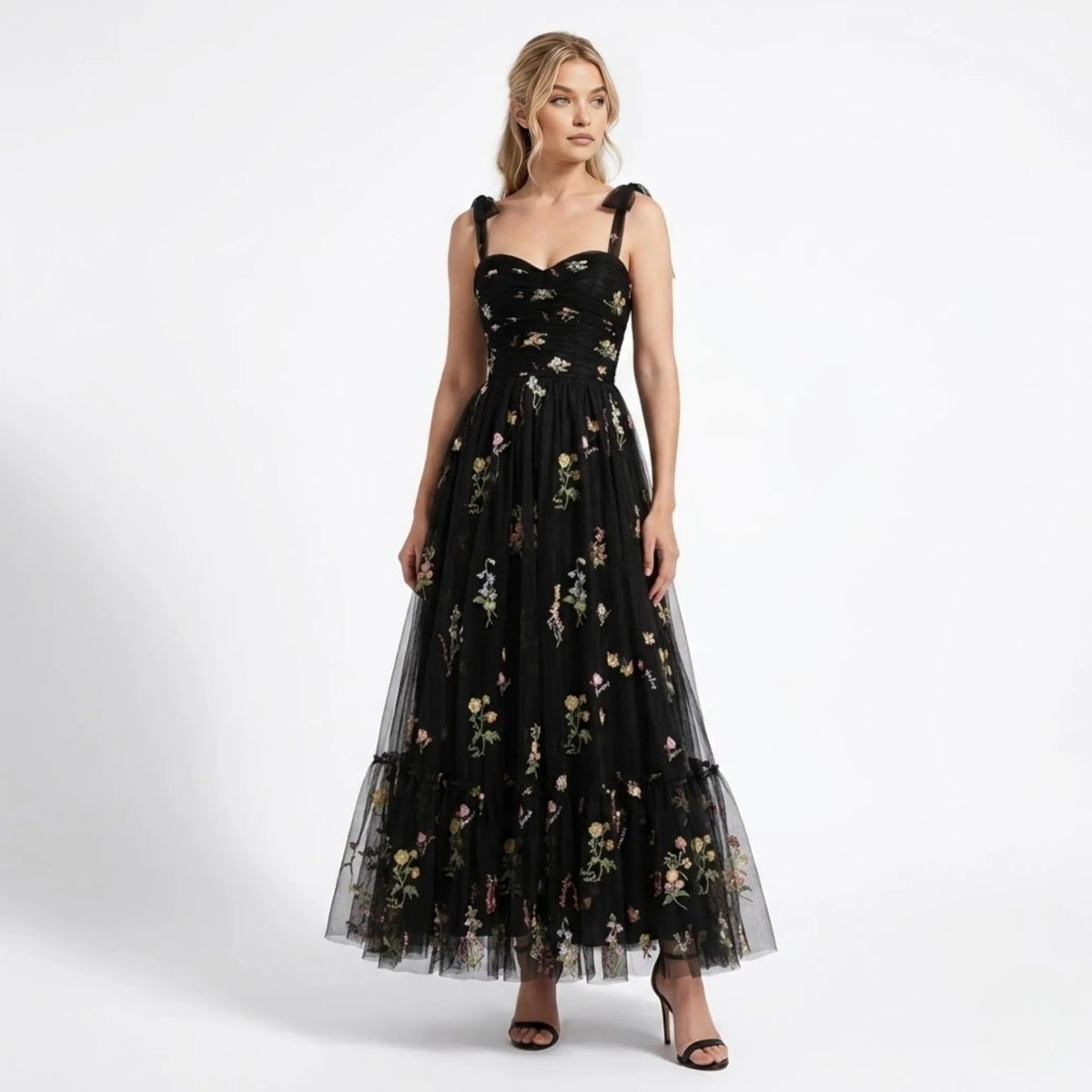 Woman wearing Kouvr black floral embroidered tulle maxi dress with sweetheart neckline and tie straps, front full length view.