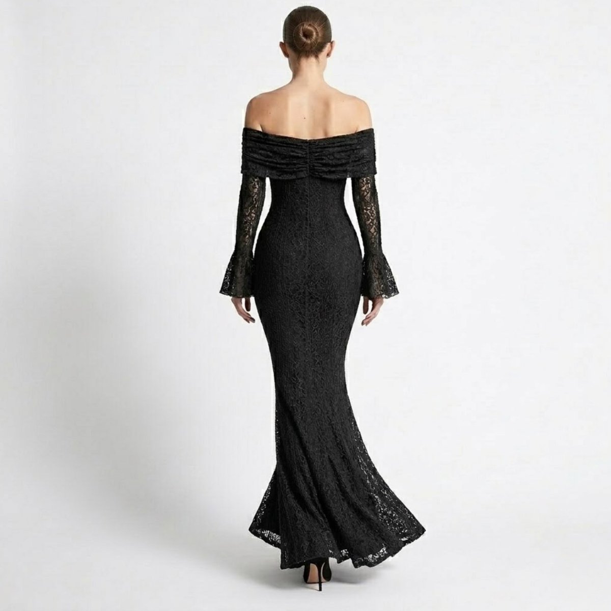 Back view of a fitted black lace maxi dress showing the floor-length sweeping hemline and off-the-shoulder back detailing