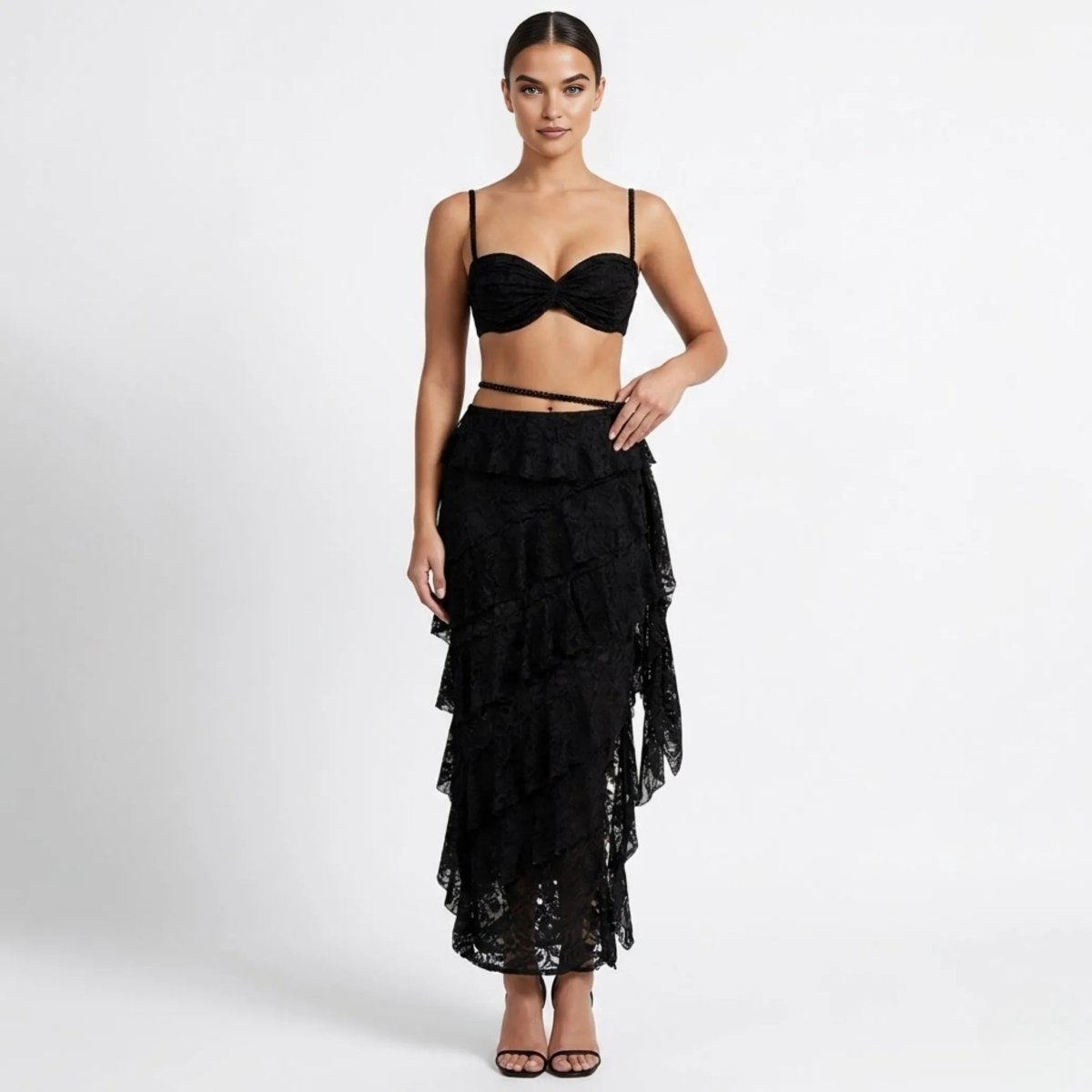 Woman wearing Kouvr black sheer lace two piece matching set with tiered ruffle maxi skirt and sweetheart bralette front view