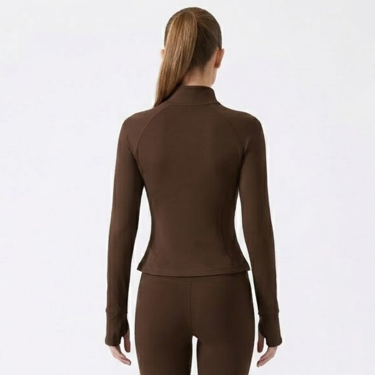 Back view of woman wearing chocolate brown fitted zip-up activewear jacket showing tailored seams