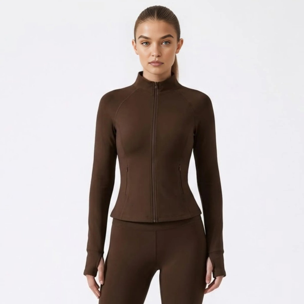 Front view of woman wearing brown fitted zip-up activewear jacket by Kouvr