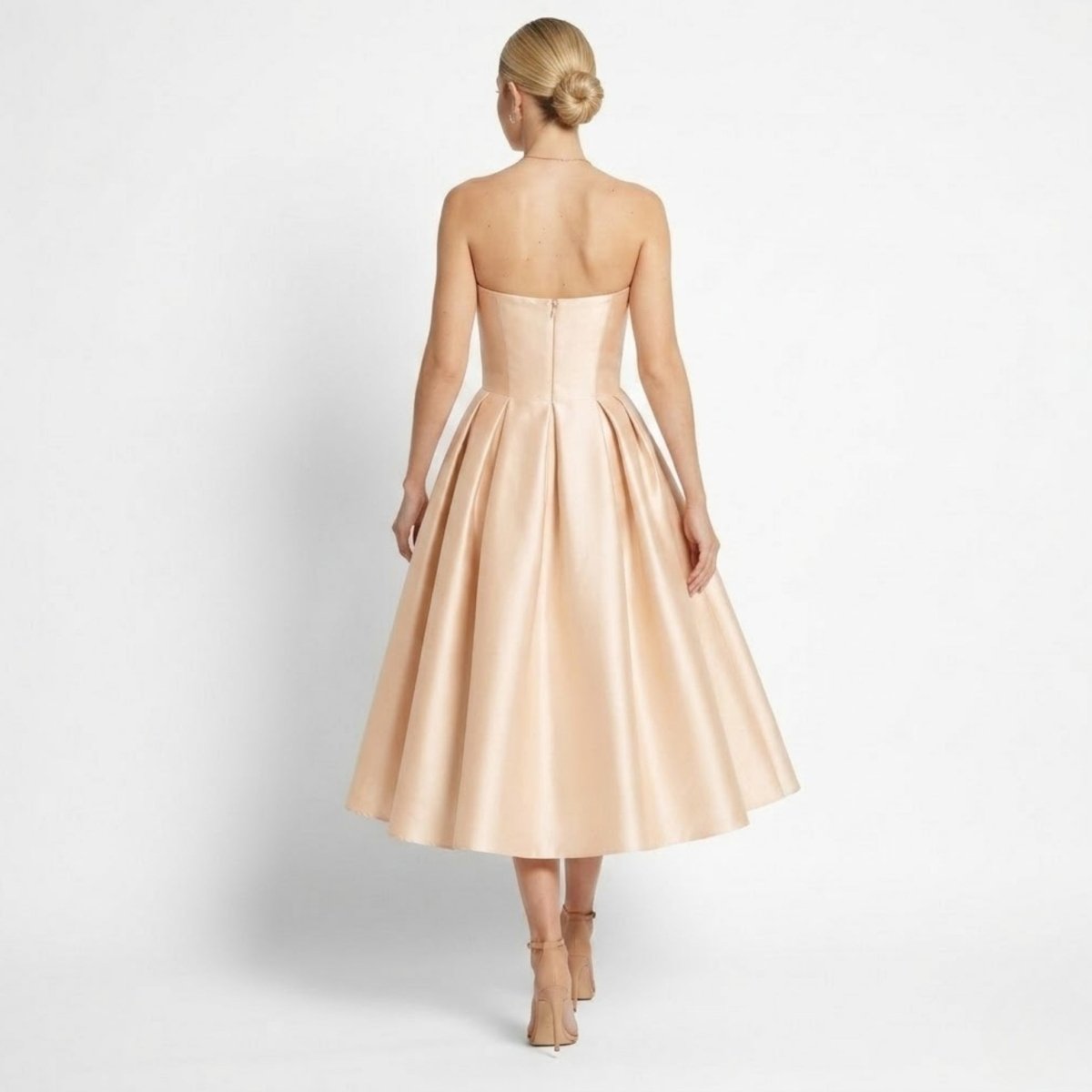Back view of strapless formal evening dress showing invisible zipper, tailored bodice, and elegant updo