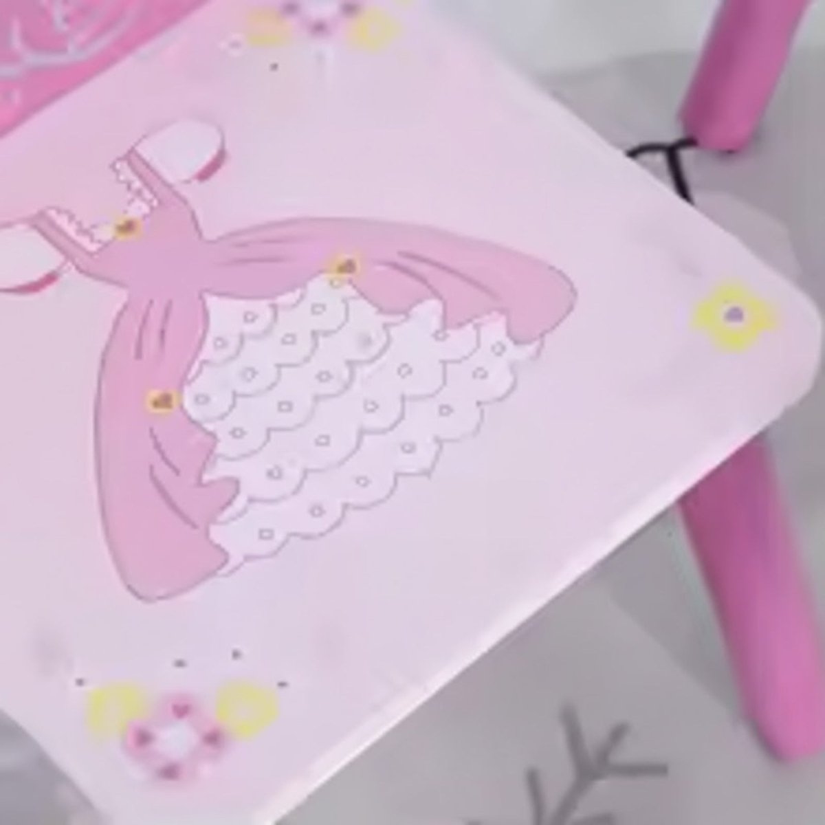 A close-up detail shot of the pink princess ball gown illustration on the seat of the Kouvr children's chair.