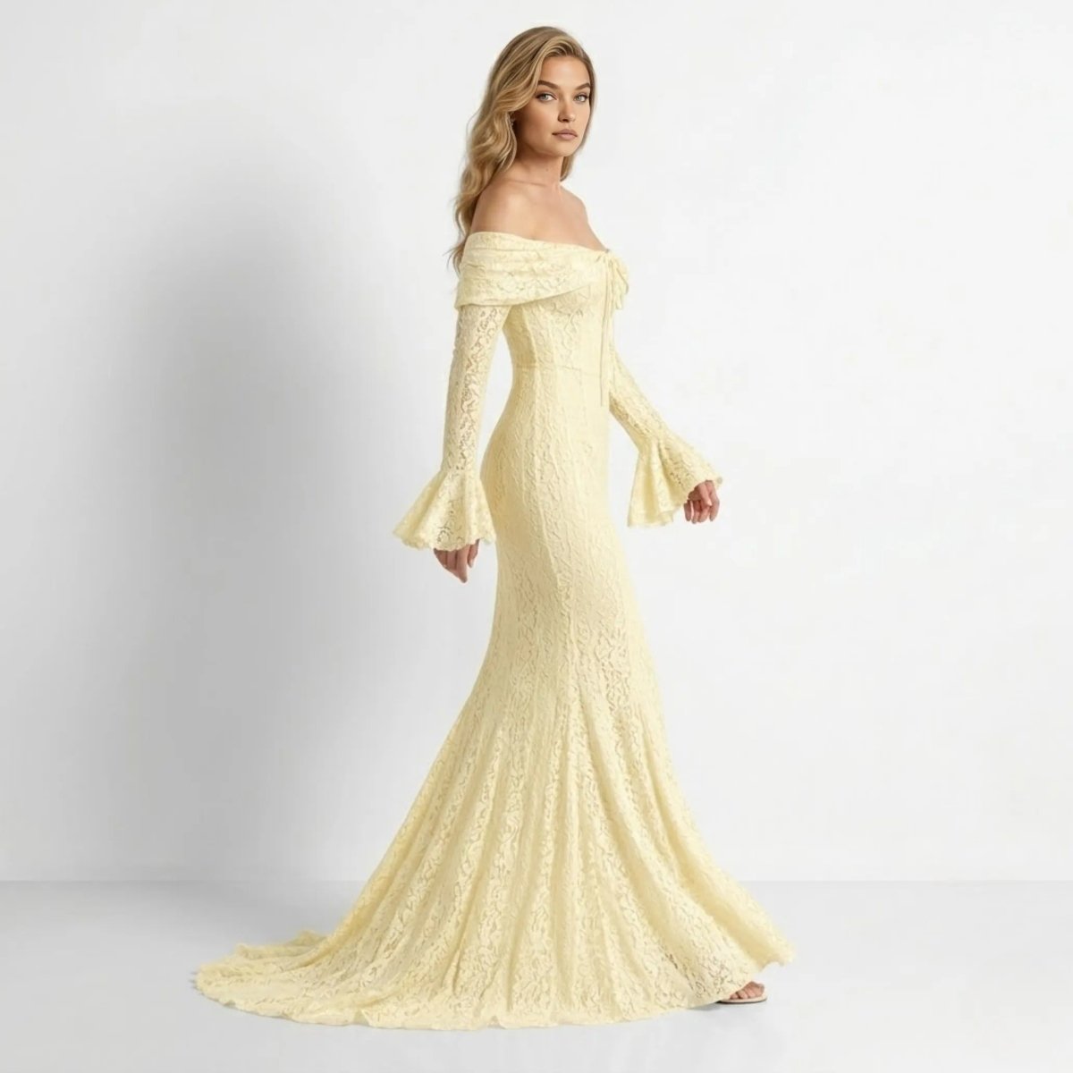 Side angle view of cream yellow lace mermaid silhouette evening gown showing fitted bodice and flared hem