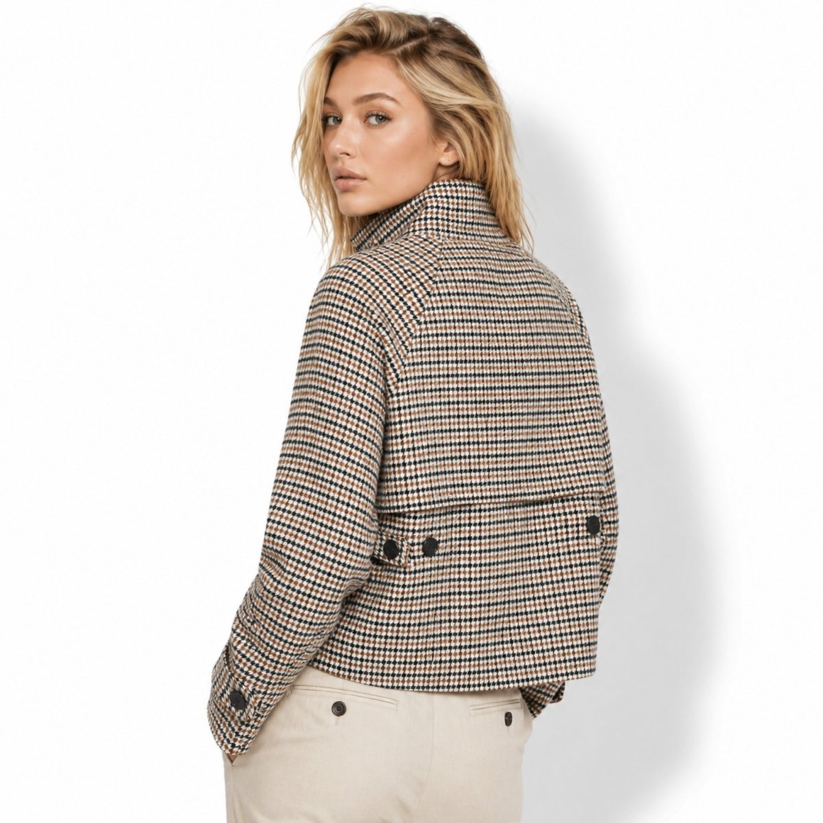 Back view of a women's cropped houndstooth jacket featuring a structured back storm flap with button accents.