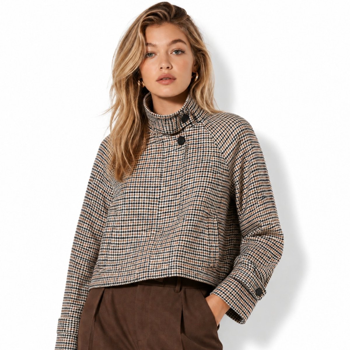 Half-body shot of a model wearing a chic high neck houndstooth tweed jacket styled with brown trousers for a smart casual autumn look.