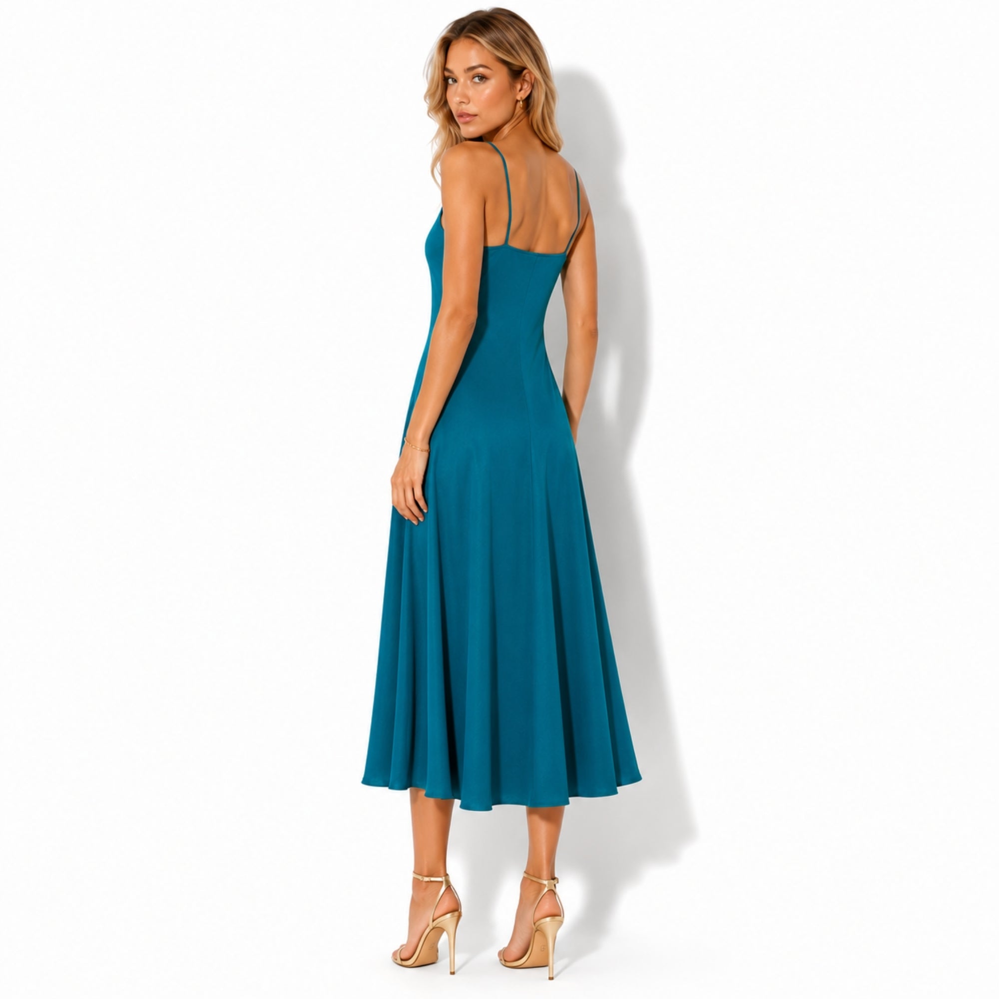 Back view of a flowy blue linen midi dress showing delicate shoulder straps and a smooth, elegant drape.
