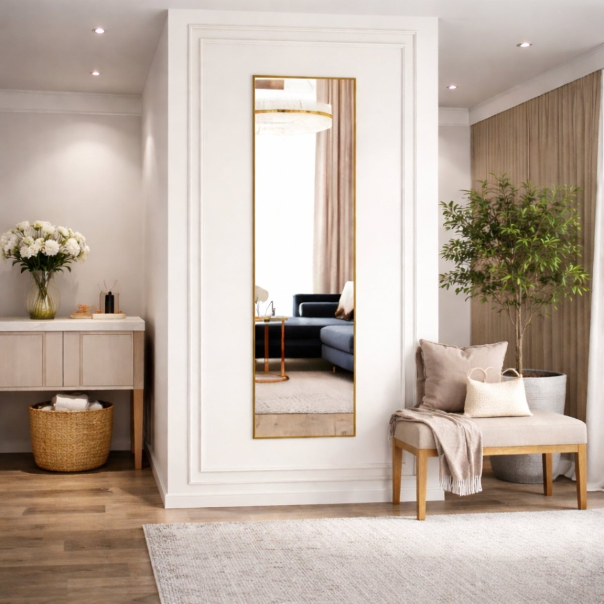 Tall rectangular gold full length mirror with aluminum frame leaning against a white wall in an elegant entryway.