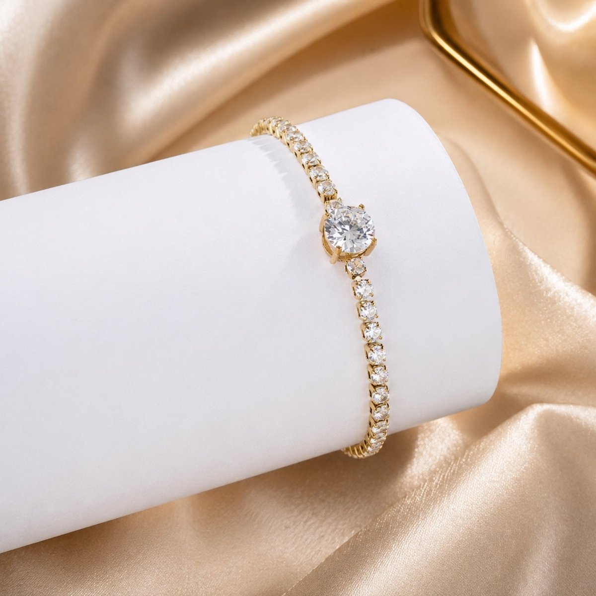 Close up of 8mm center stone gold tennis bracelet displayed on white cylinder against gold silk