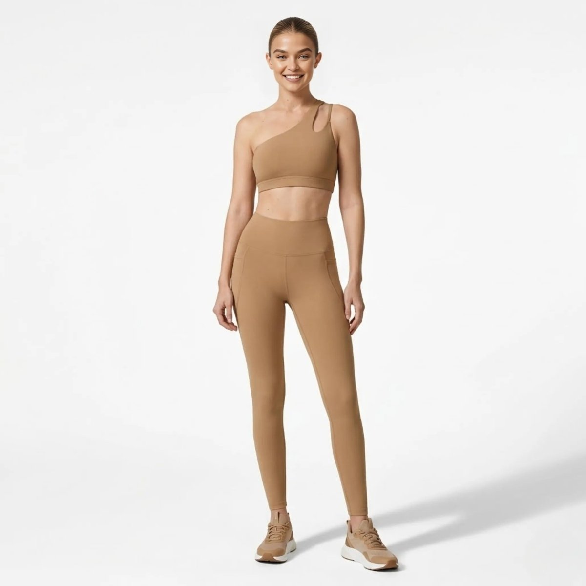 Front view of woman wearing Kouvr khaki asymmetrical one shoulder sports bra and high waisted legging activewear set