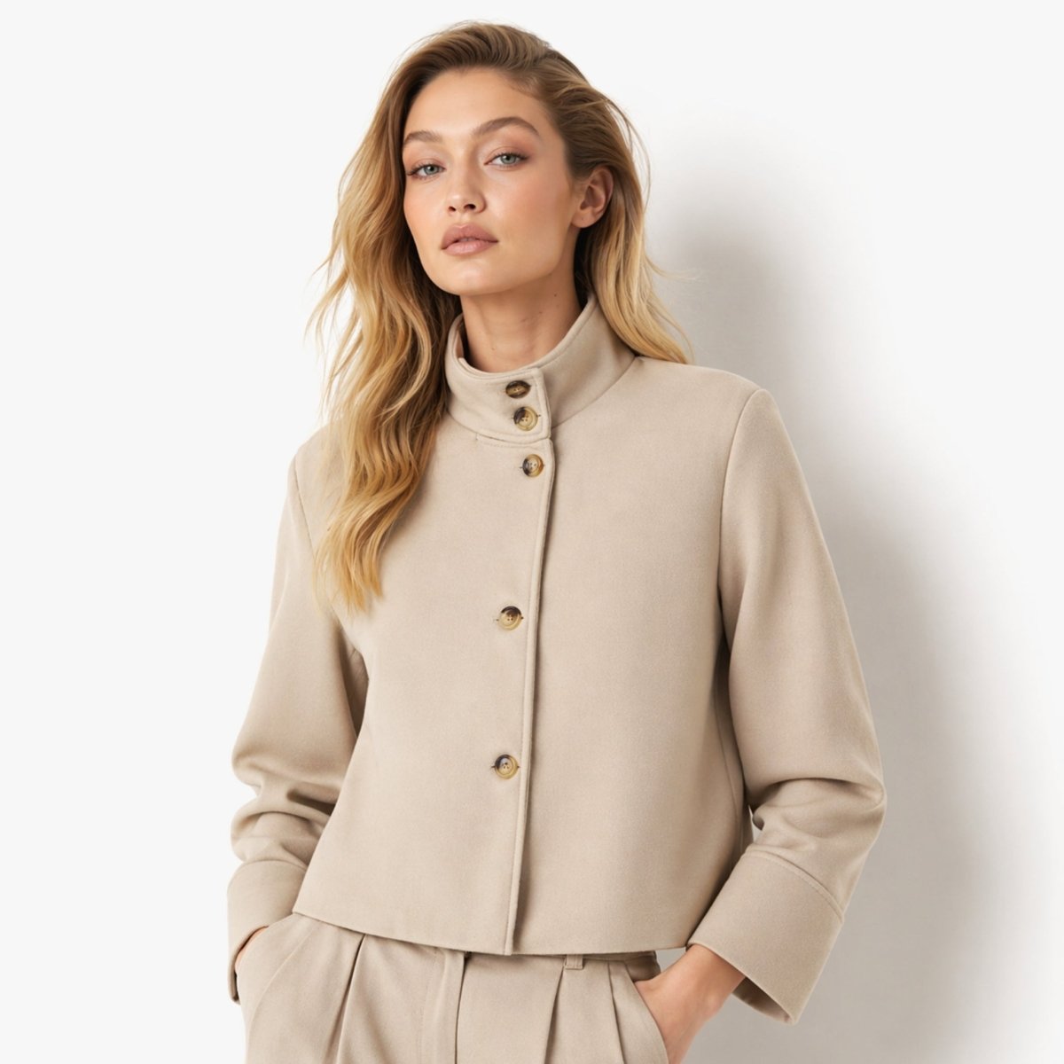 Woman wearing a khaki wool blend cropped stand collar jacket with tortoiseshell buttons by Kouvr.