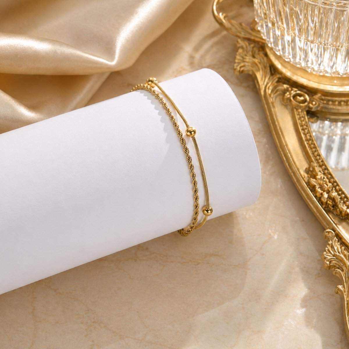 Close up of a woman's foot in the sand wearing the Kouvr waterproof gold layered anklet.