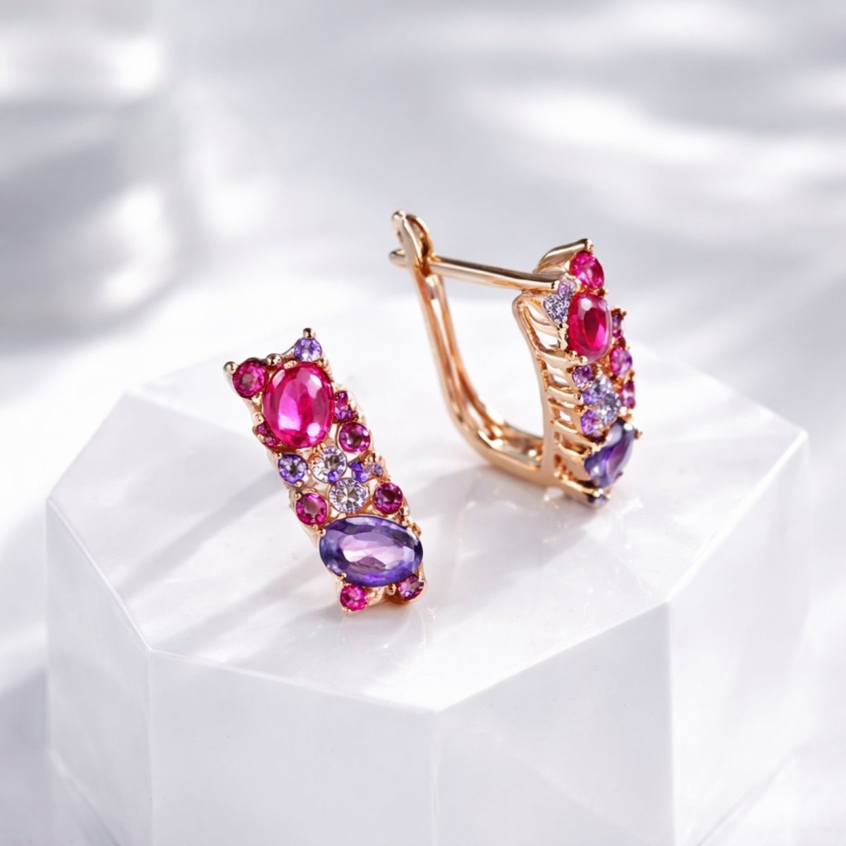 Kouvr Aileen rose gold and multi-gemstone earrings positioned on a white geometric block, highlighting the intricate design and brilliant sparkle of the stones.