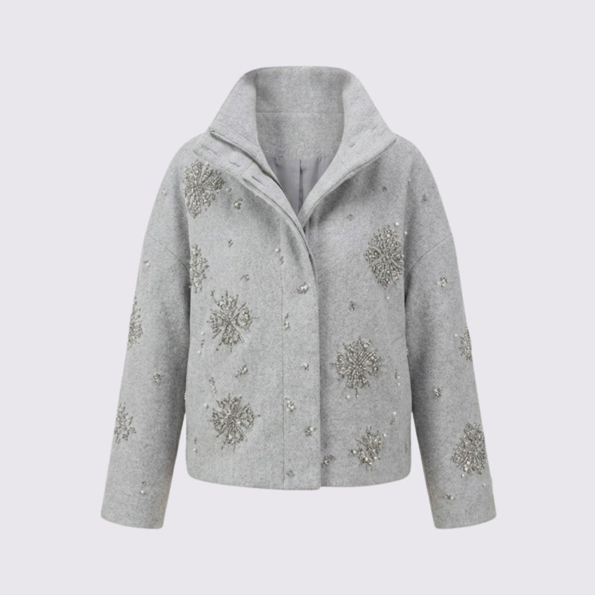 Front product shot of the Kouvr Alisa funnel neck jacket in light grey, laid flat to display the detailed silver and crystal snowflake embellishments on a light grey background.