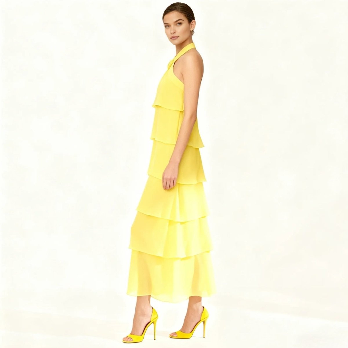 Woman wearing a yellow Kouvr tiered dress on a white background