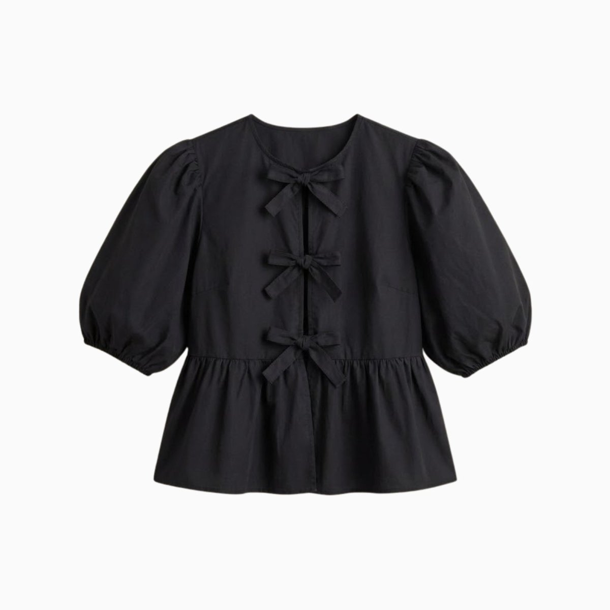 Flat lay of a black cotton poplin top with three bows down the front and voluminous puff sleeves.