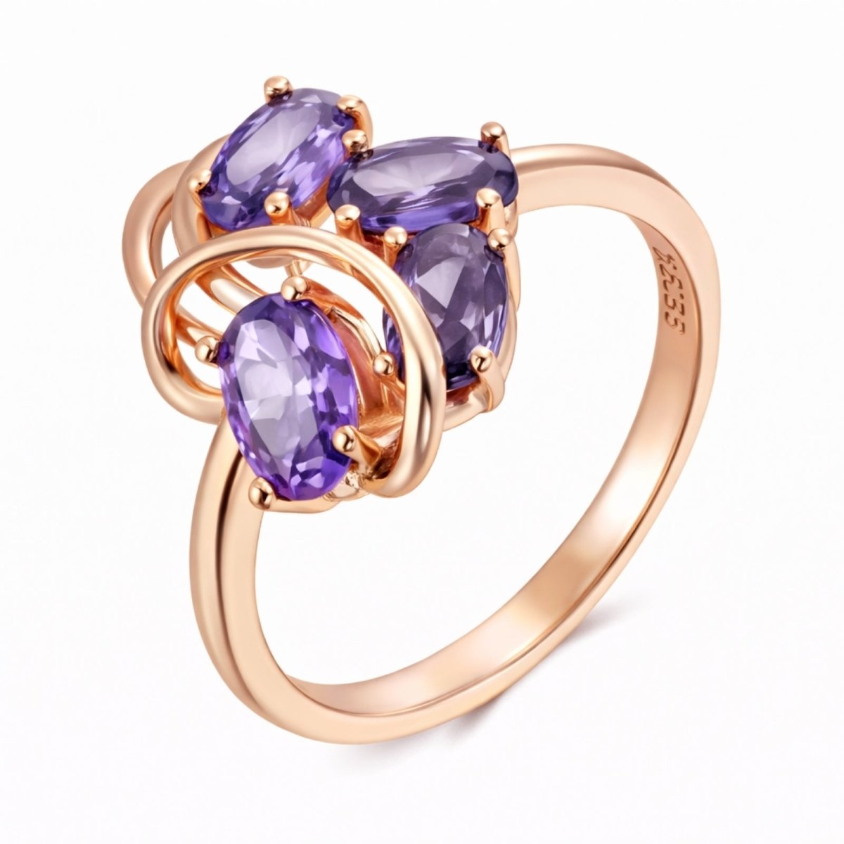 The Kouvr annika statement ring in 14k rose gold featuring four oval purple natural zircons in an intertwined cluster design on a white background.