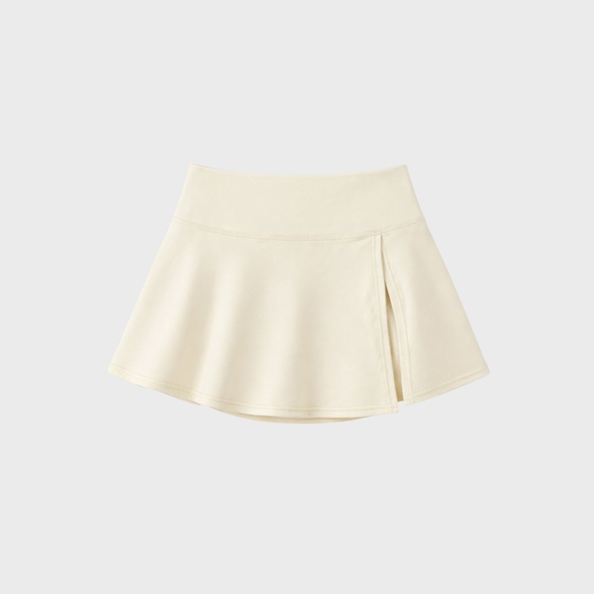 Close up flat lay of Kouvr premium apricot high-waisted athletic mini skort highlighting subtle front side slit