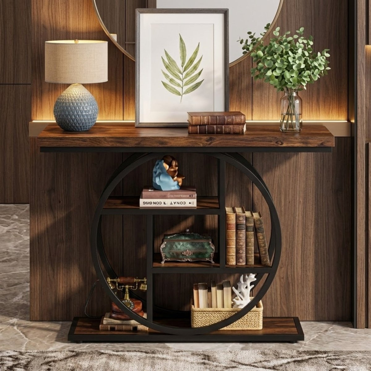 The Kouvr Arcelia geometric circle console table styled in a modern entryway with a lamp, art, and decor on its rustic wood shelves and black metal frame.