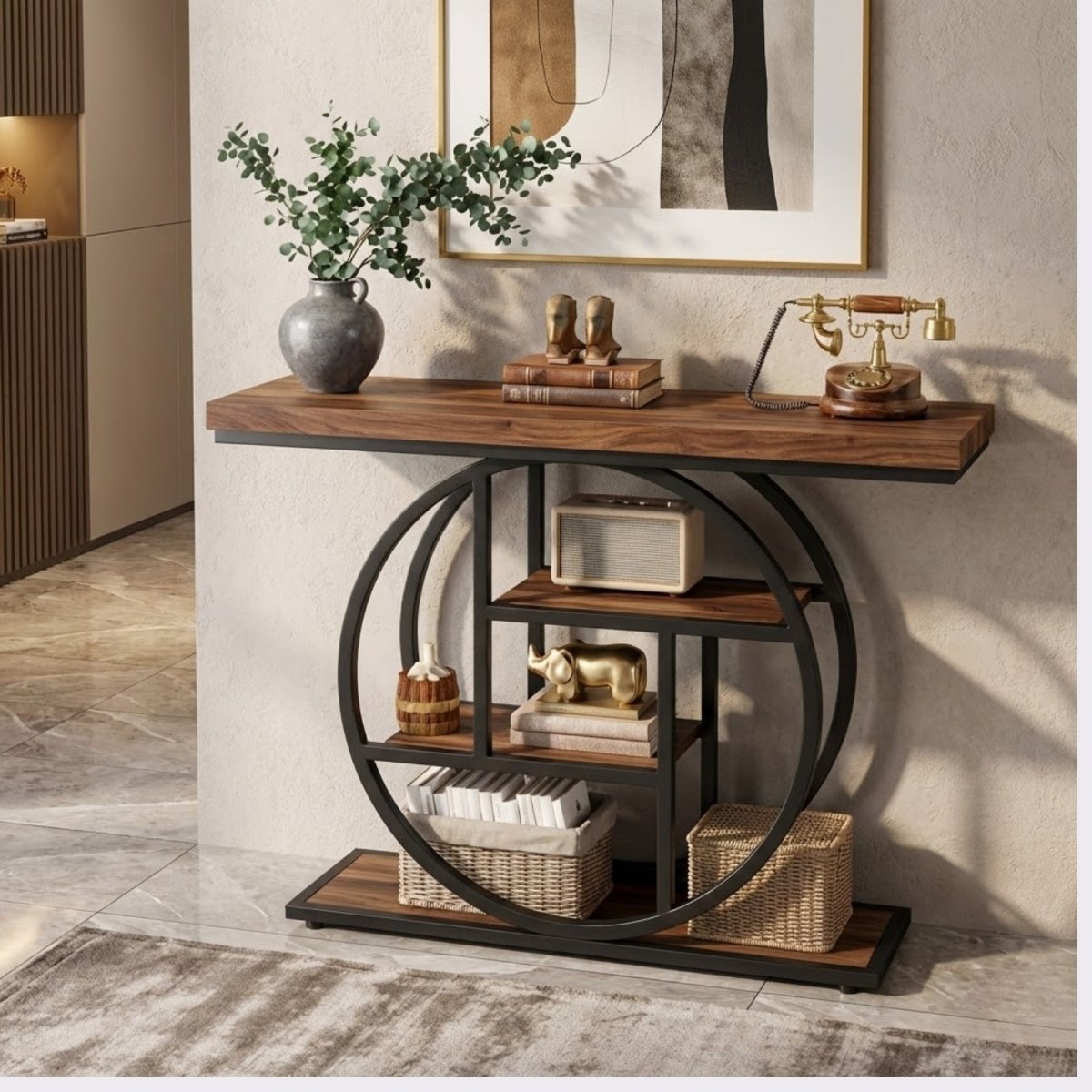 A luxury console table with a gold metal circle frame and white marble shelves, styled in a classic living room next to a leather chair.
