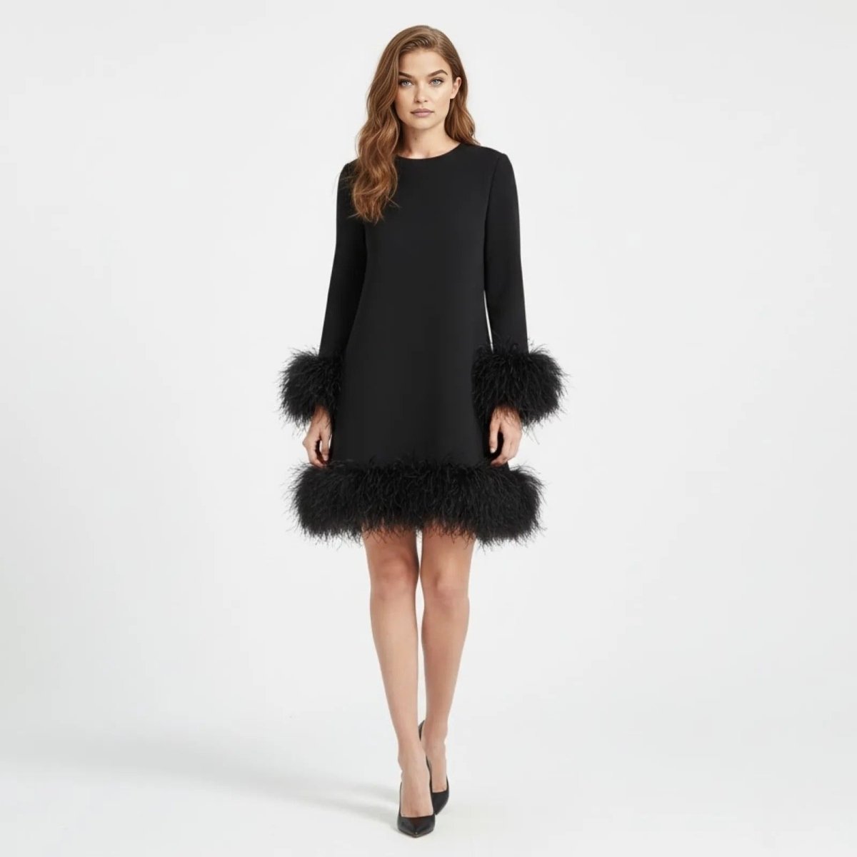 Model facing forward in the Arica black long sleeve party dress by Kouvr, showcasing the bold feather trim and mini length.