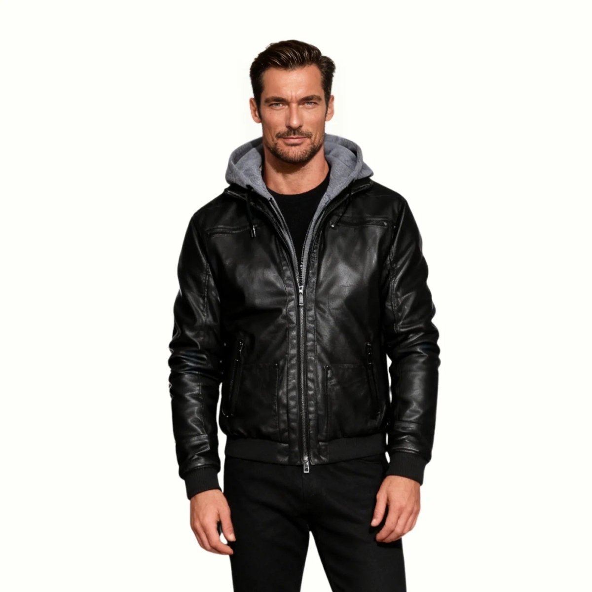 Model wearing the Kouvr Ascend men's black leather bomber jacket with a grey hood, showcasing a modern, casual front view.