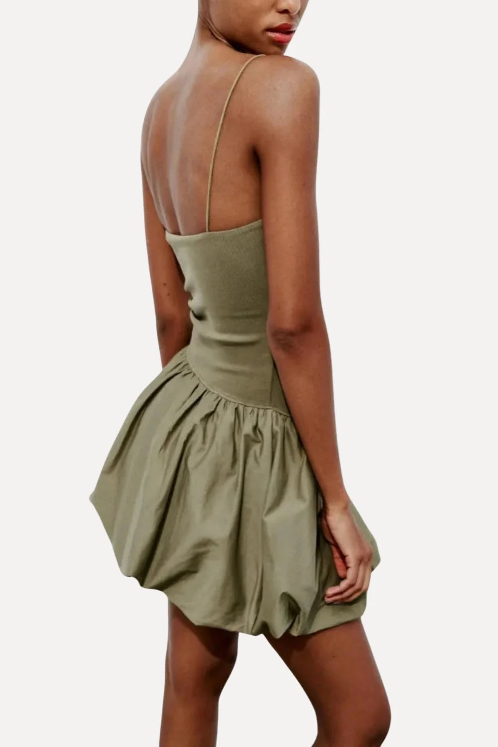 Model from the back wearing the Kouvr Aubrey olive green drop waist mini dress with a sculptural bubble skirt