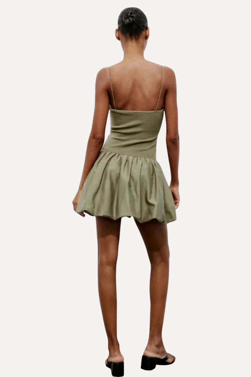 Model from the back wearing the Kouvr Aubrey olive green drop waist mini dress with a sculptural bubble skirt