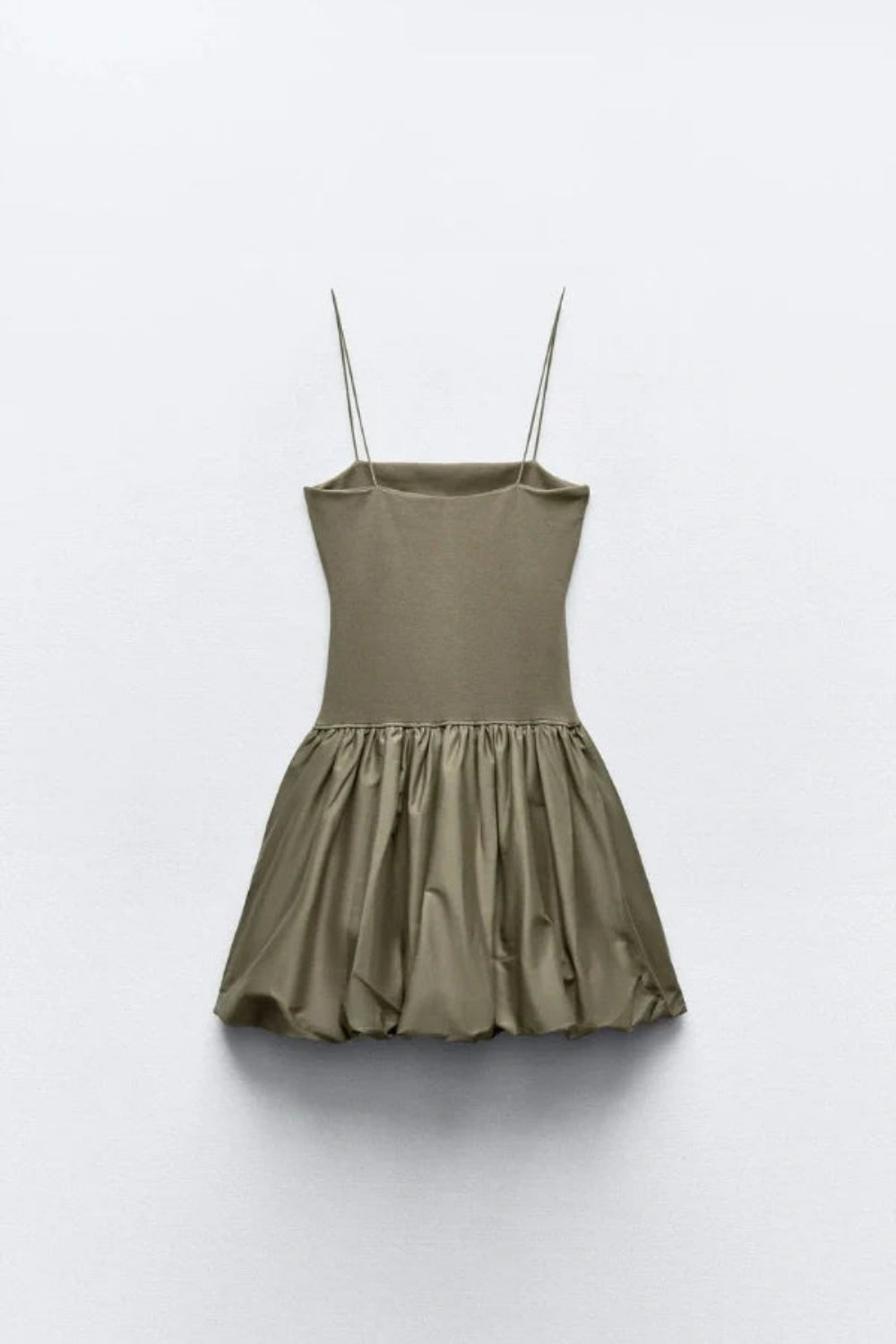 Model from the back wearing the Kouvr Aubrey olive green drop waist mini dress with a sculptural bubble skirt