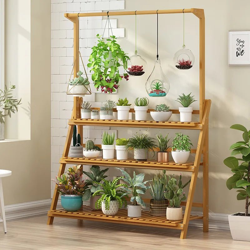 The Kouvr bamboo plant etagere styled in a bright, modern living room, filled with a variety of succulents, hanging terrariums, and potted plants.