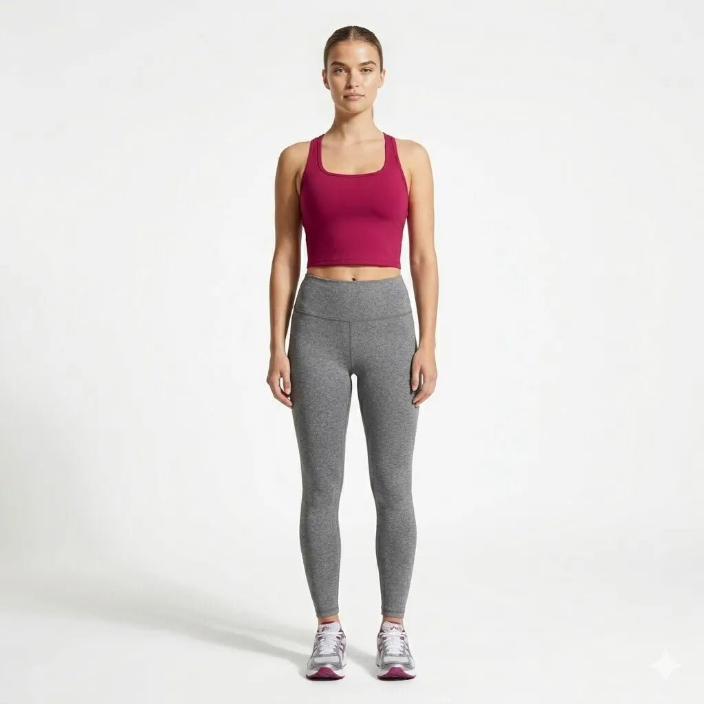 Full body lifestyle shot of model wearing Kouvr berry red workout crop top with grey athletic leggings and running sneakers