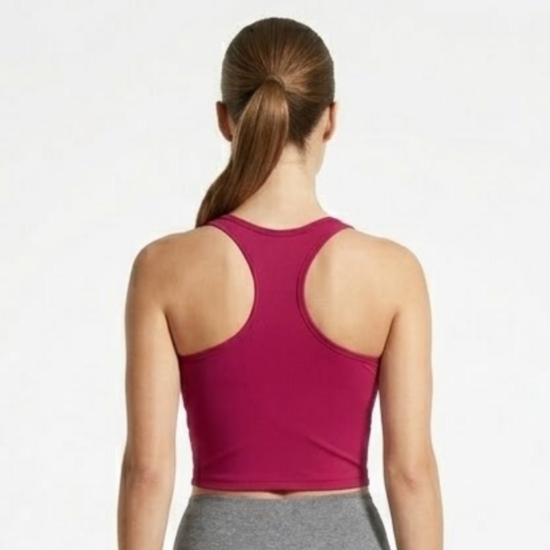 Back view of Kouvr berry red racerback athletic sports bra on model showing strap details and shoulder blade mobility