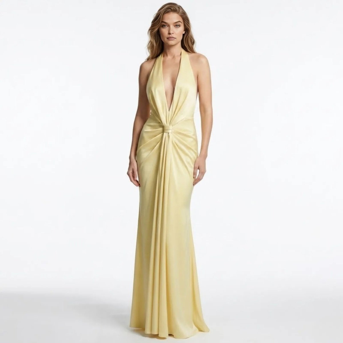 Model wearing the Kouvr Beverly light yellow velvet halter gown with a plunging neckline and knot front detail.