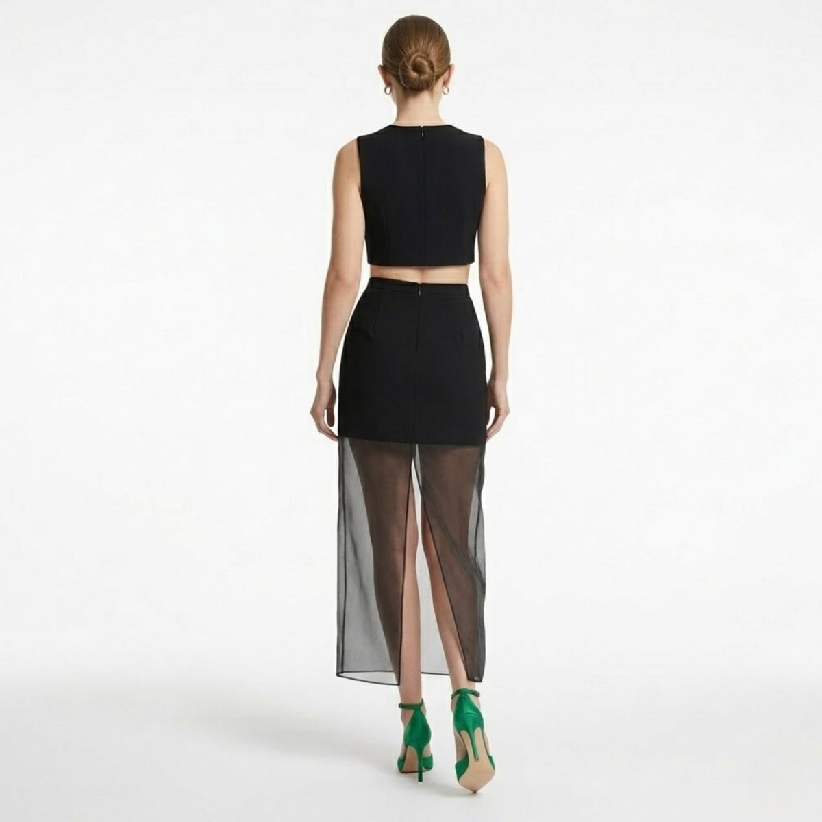 Back view of black high waisted evening skirt showing invisible zipper and sheer back slit detail for easy movement