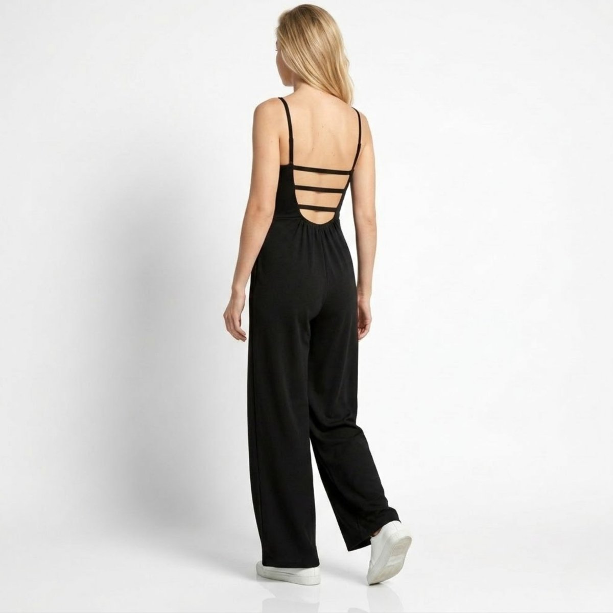 Back view of woman wearing Kouvr black jumpsuit featuring a multi-strap open back design