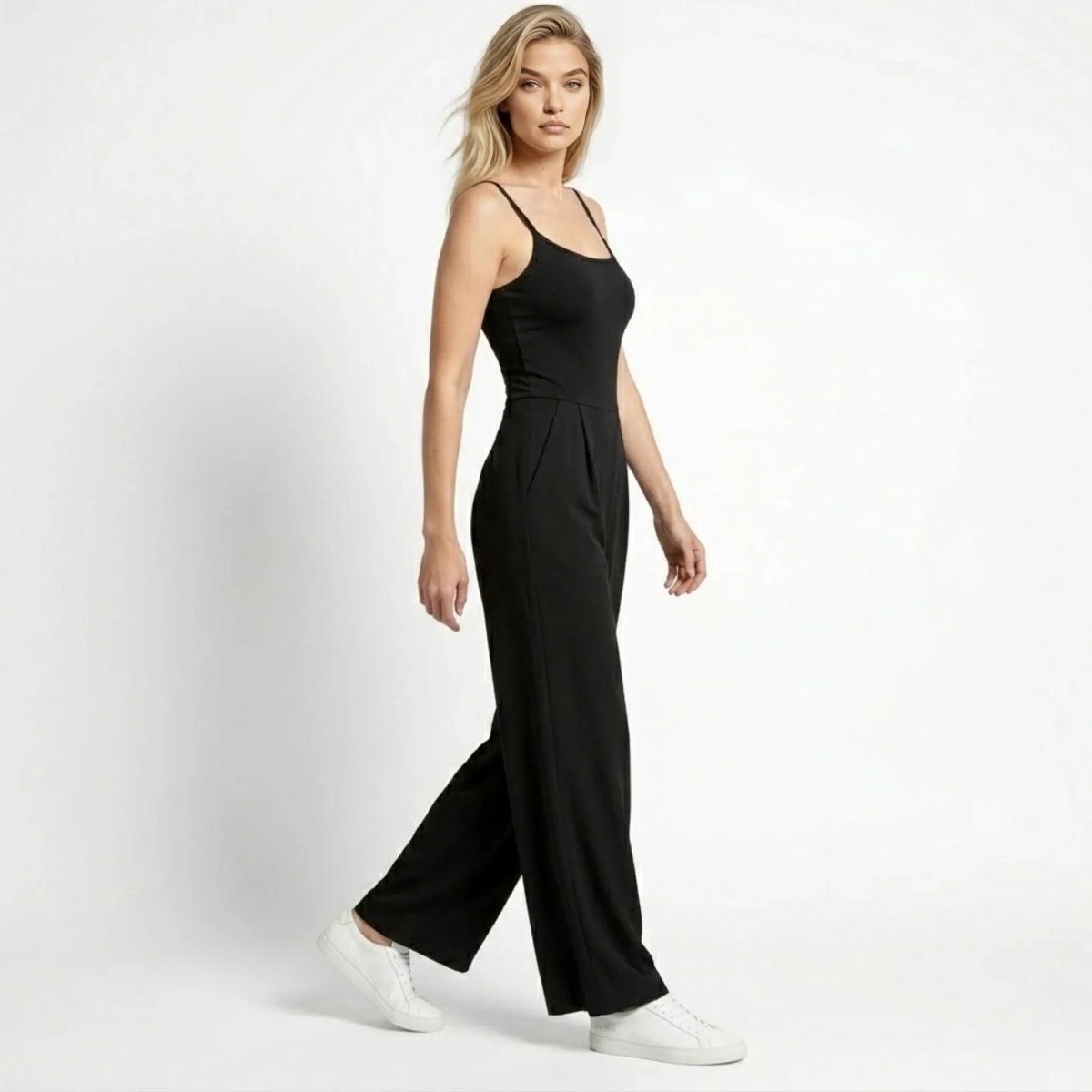 Side profile of woman walking in Kouvr black wide leg pleated jumpsuit