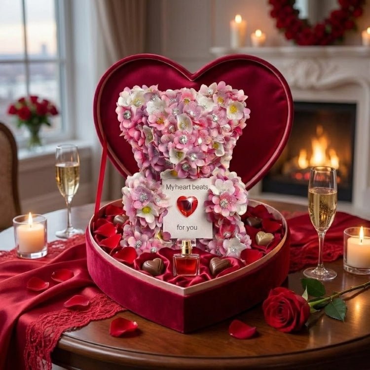 The Kouvr Blossom & Jewel Bear presented in a luxurious red velvet, heart-shaped gift box with chocolates, a red rose, and candles.