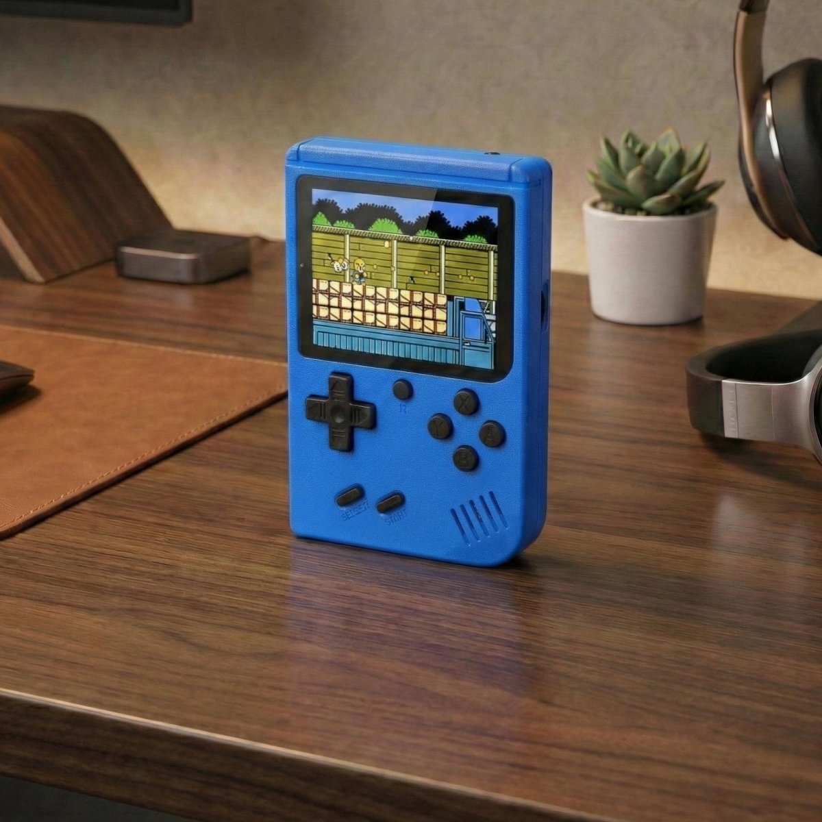 Blue Kouvr retro handheld game console with a 3-inch color screen showing a classic 8-bit game.