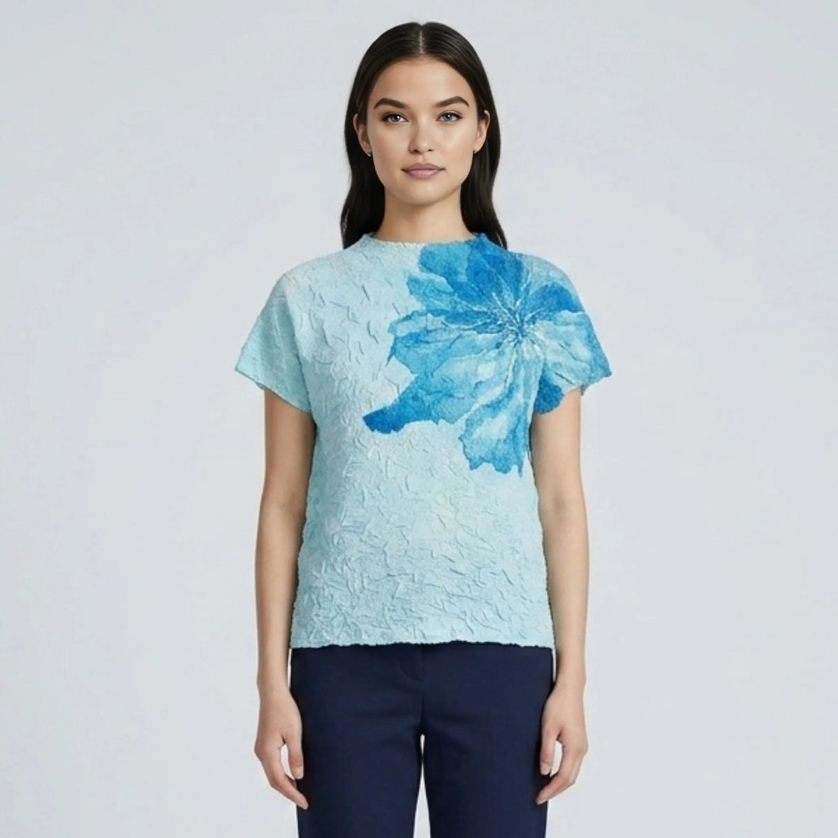 Women's blue textured crinkle blouse with dark blue asymmetrical floral print front view styled with navy pants
