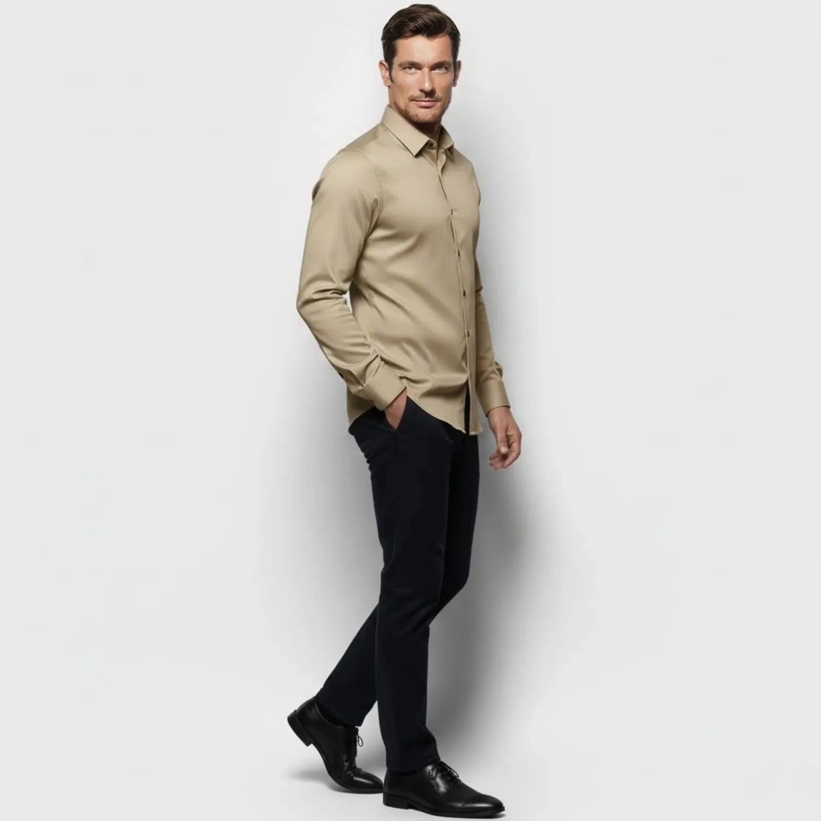 Side profile of a male model in the Kouvr Briar khaki long sleeve performance shirt, highlighting its tailored fit.