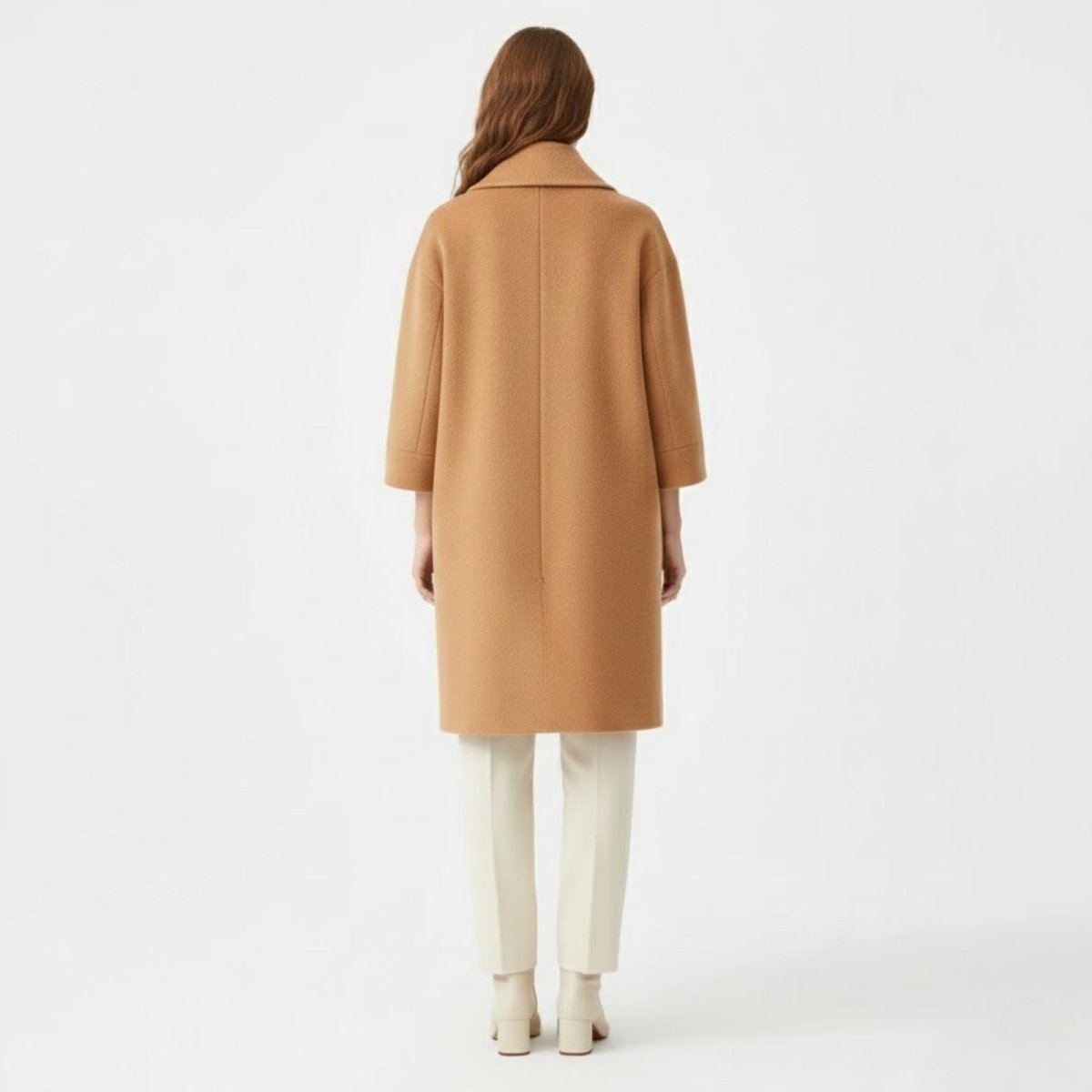 Back view of the Kouvr knee-length camel wool coat showing its relaxed silhouette.