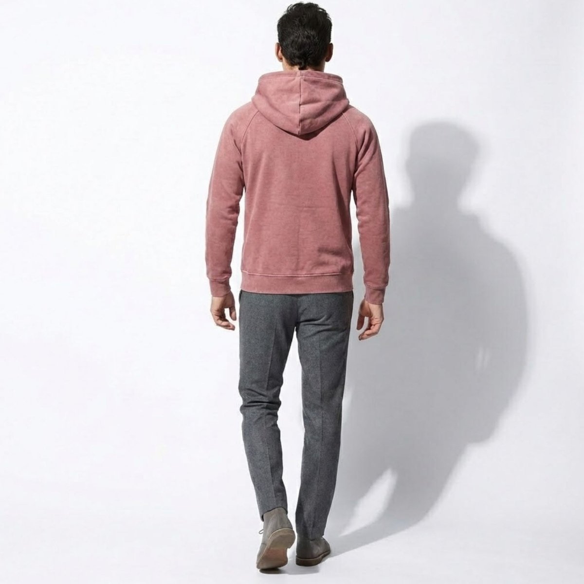 Back view of a man walking away wearing the Kouvr pink hoodie with raglan sleeves.