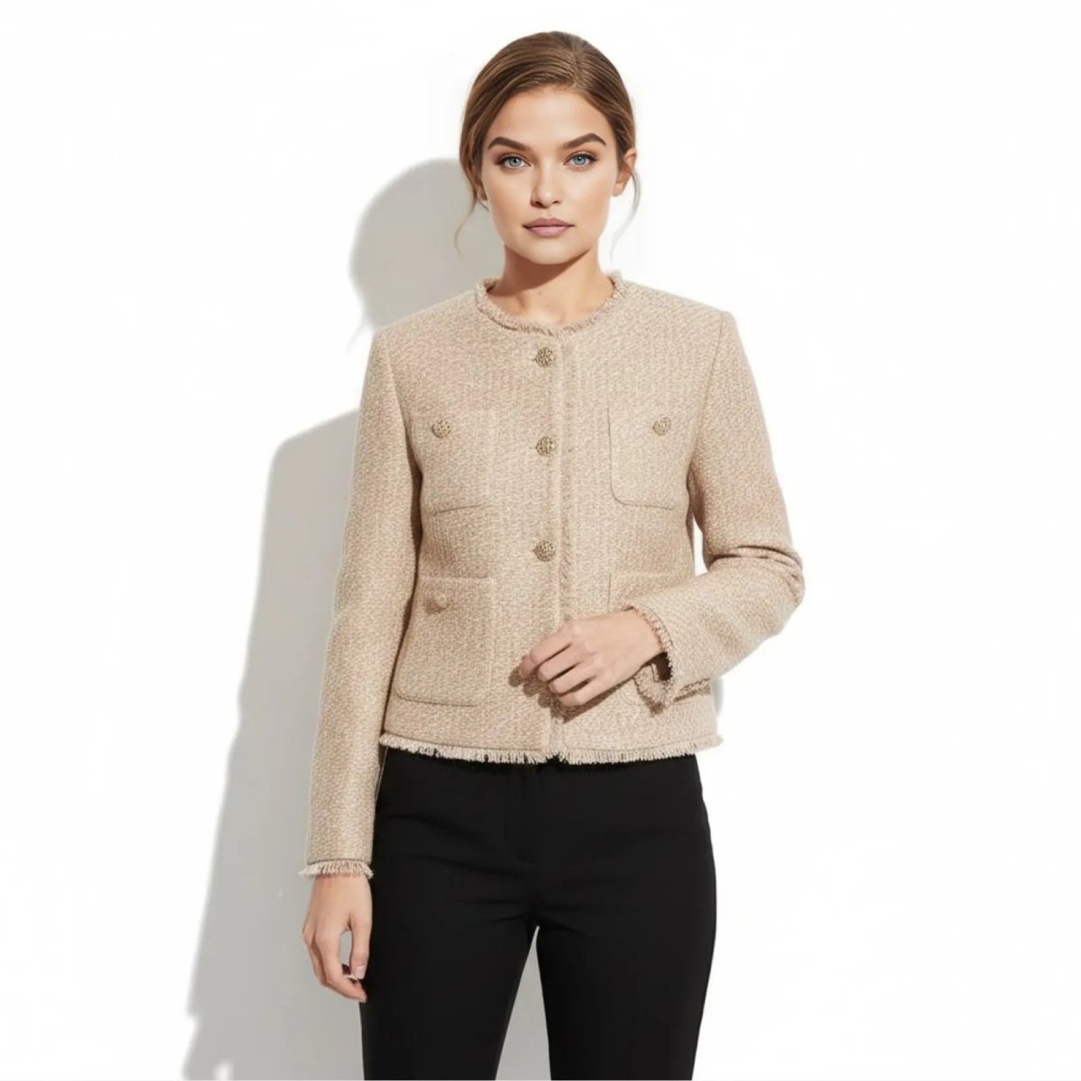 Model wearing the Kouvr Classic Tweed Jacket in beige, a collarless boucle style with gold buttons and fringe trim, paired with black trousers.